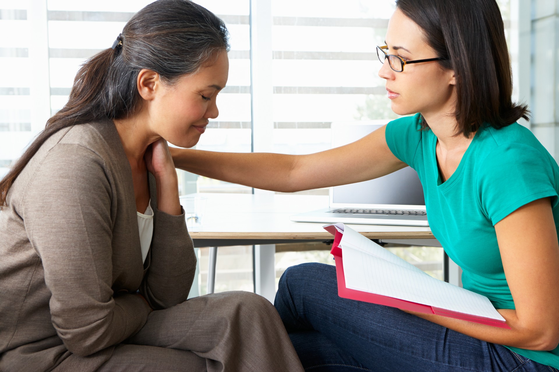 Counsellor comforting woman in counselling section